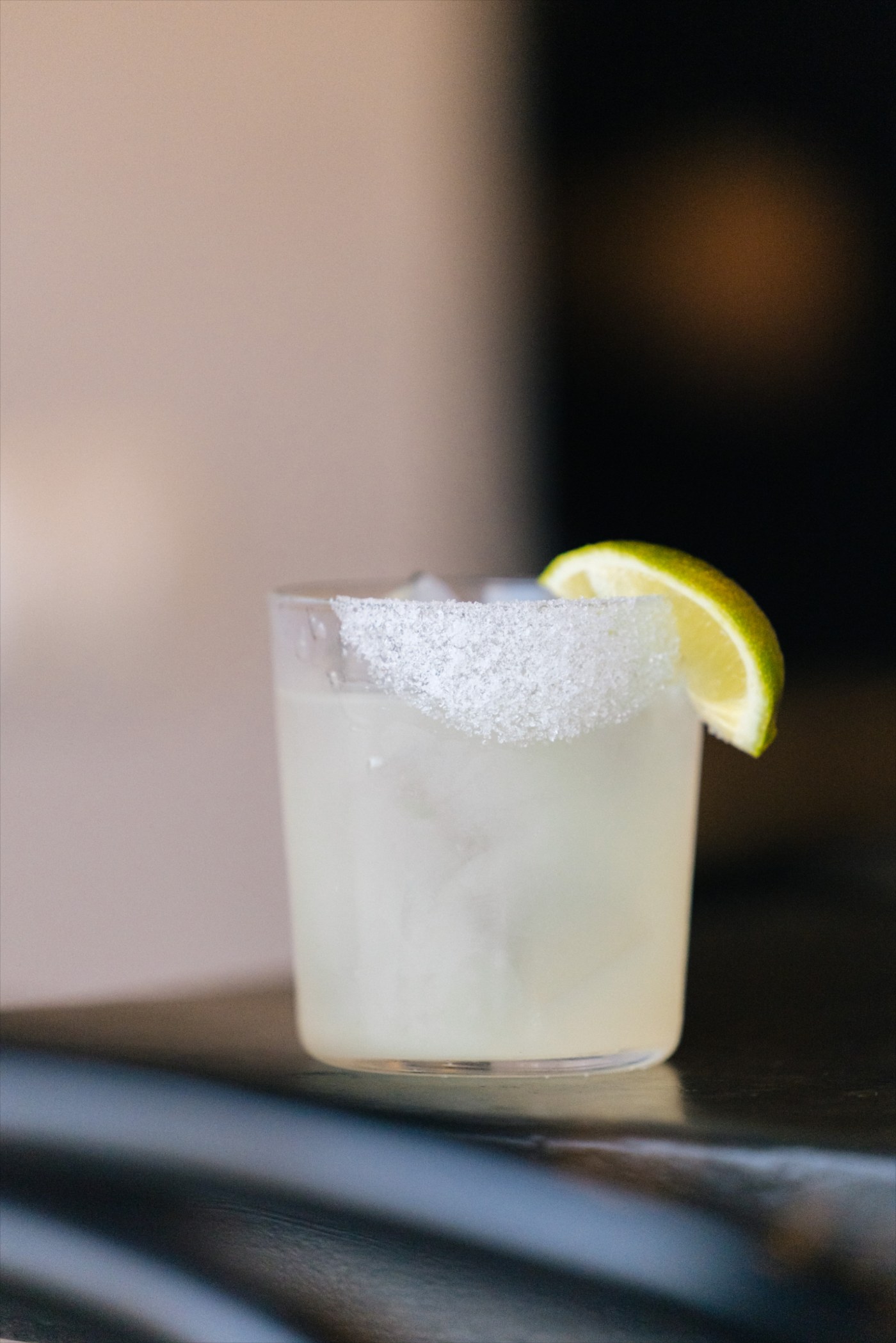 A margarita with a salted rim and a lime wedge